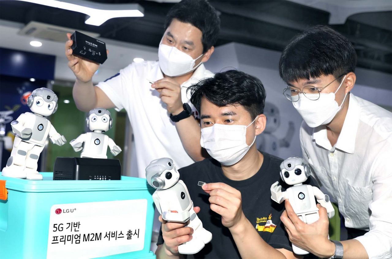 LG유플러스 임직원이 로봇을 이용한 ‘프리미엄 사물지능통신(M2M)’ 서비스를 시연하고 있다. [LG유플러스 제공]