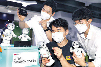 LG유플러스 임직원이 로봇을 이용한 ‘프리미엄 사물지능통신(M2M)’서비스를 시연하고 있다. [LG유플러스 제공]