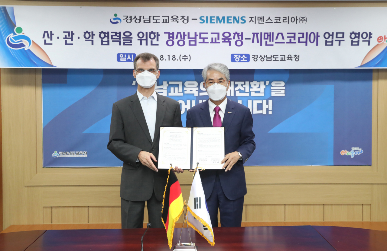 18일 경남 창원시 경남교육청에서 토마스 슈미드 한국지멘스 디지털 인더스트리 부문 대표(왼쪽)와 박종훈 경남교육감이 산업 전문 인력 양성을 위한 산학 협력 협약 후 기념 촬영을 하고 있다.[한국지멘스 제공]