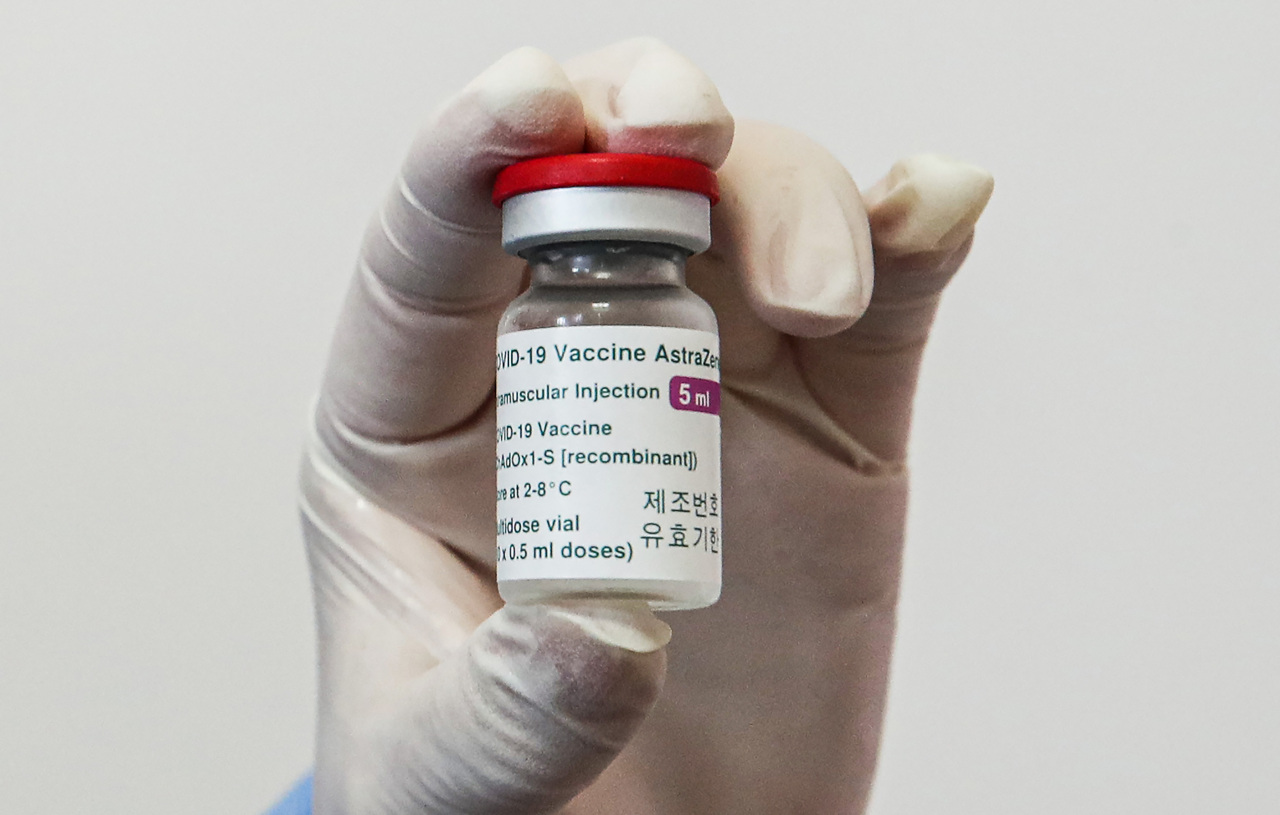 Health worker holds a vial of AstraZeneca COVID-19 vacicne. (Yonhap)
