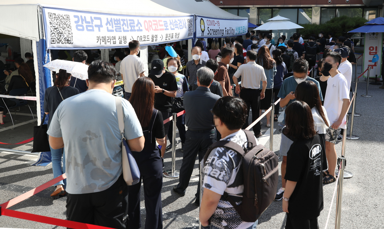 국내 코로나19 확산세가 지속하면서 신규 확진자 수가 2000명대를 기록한 20일 오전 서울 강남구보건소에 마련된 선별진료소를 찾은 시민들이 코로나19 선별검사를 받기 위해 줄을 서 있다. 중앙방역대책본부에 따르면 이날 0시 기준 신규 확진자가 2052명 늘어 누적 23만2859명이다. [연합]