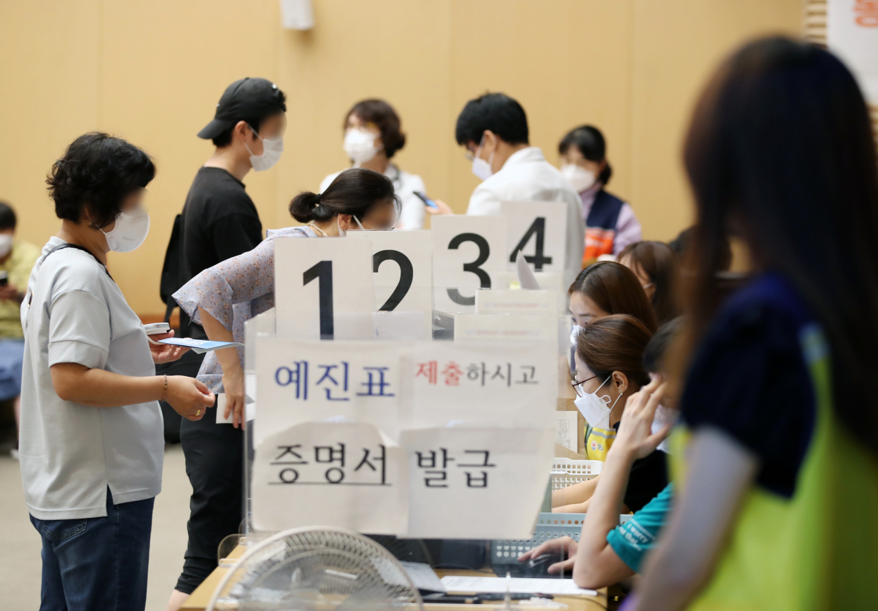 국내 코로나19 신규 확진자 수가 2052명을 기록하며 이틀째 2000대를 기록한 20일 오전 서울 양천구 예방접종센터에서 시민들이 백신 접종 뒤 증명서를 발급받고 있다. [연합]