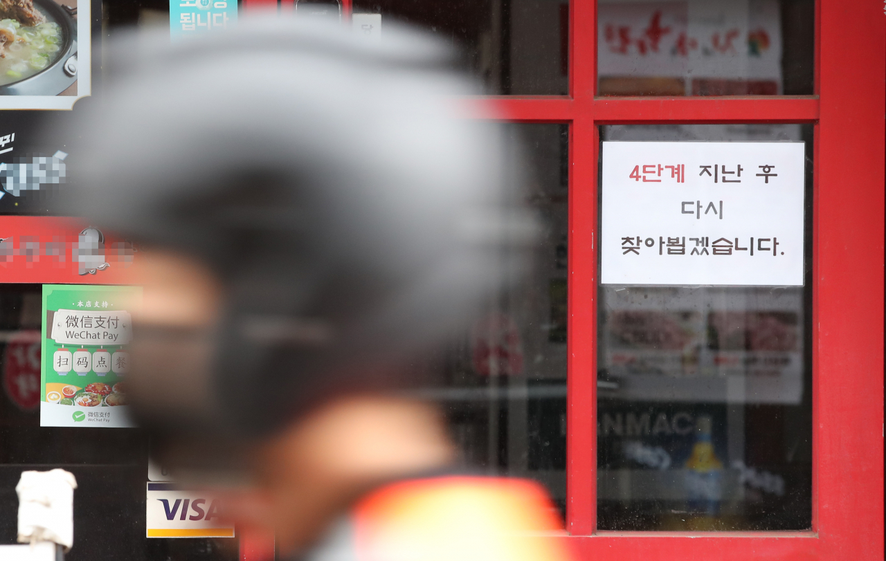 코로나19 4차 대유행 확산세가 지속함에 따라 정부가 수도권의 사회적 거리두기 4단계, 비수도권 3단계 유지를 발표한 20일 오전 서울 서대문구 신촌 거리의 한 음식점에 '거리두기 4단계' 후 영업을 재개한다는 안내문이 붙어 있다. 중앙재난안전대책본부는 이날 수도권을 비롯한 4단계 지역 식당·카페의 영업시간을 오후 10시에서 9시로 1시간 단축하고 백신 접종 인센티브를 일부 부활시켜 오후 6시 이후로도 식당·카페에서는 접종 완료자를 포함해 최대 4명까지 모일 수 있도록 했다. 이번 조정안은 23일 0시부터 9월 5일 자정까지 적용될 예정이다. [연합]