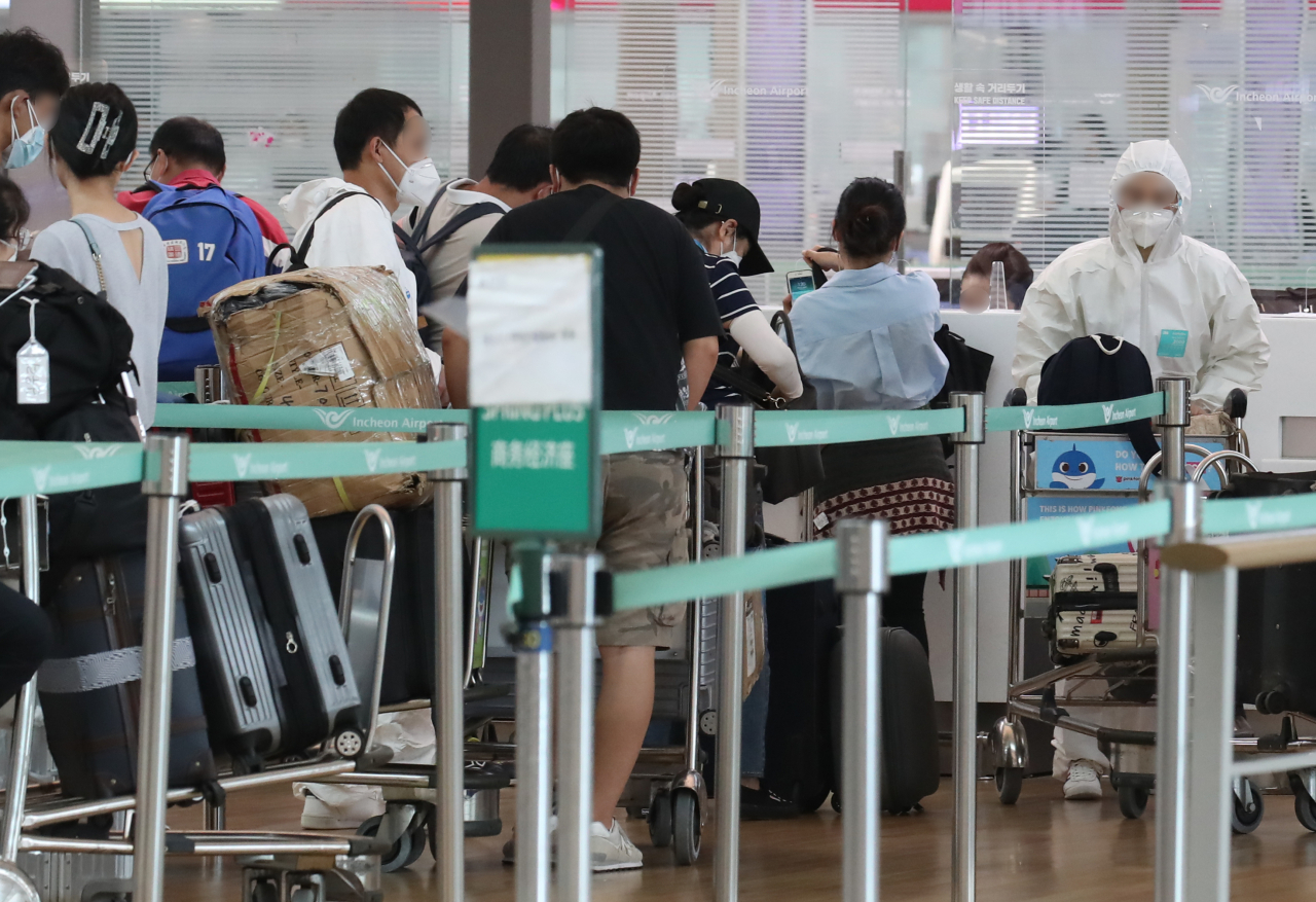 20일 오후 인천국제공항 제1여객터미널 출국장에서 방역복과 고글로 중무장한 한 해외 출국자가 출국 수속을 하고 있다.(사진은 기사 내용과 관련없음) [연합]