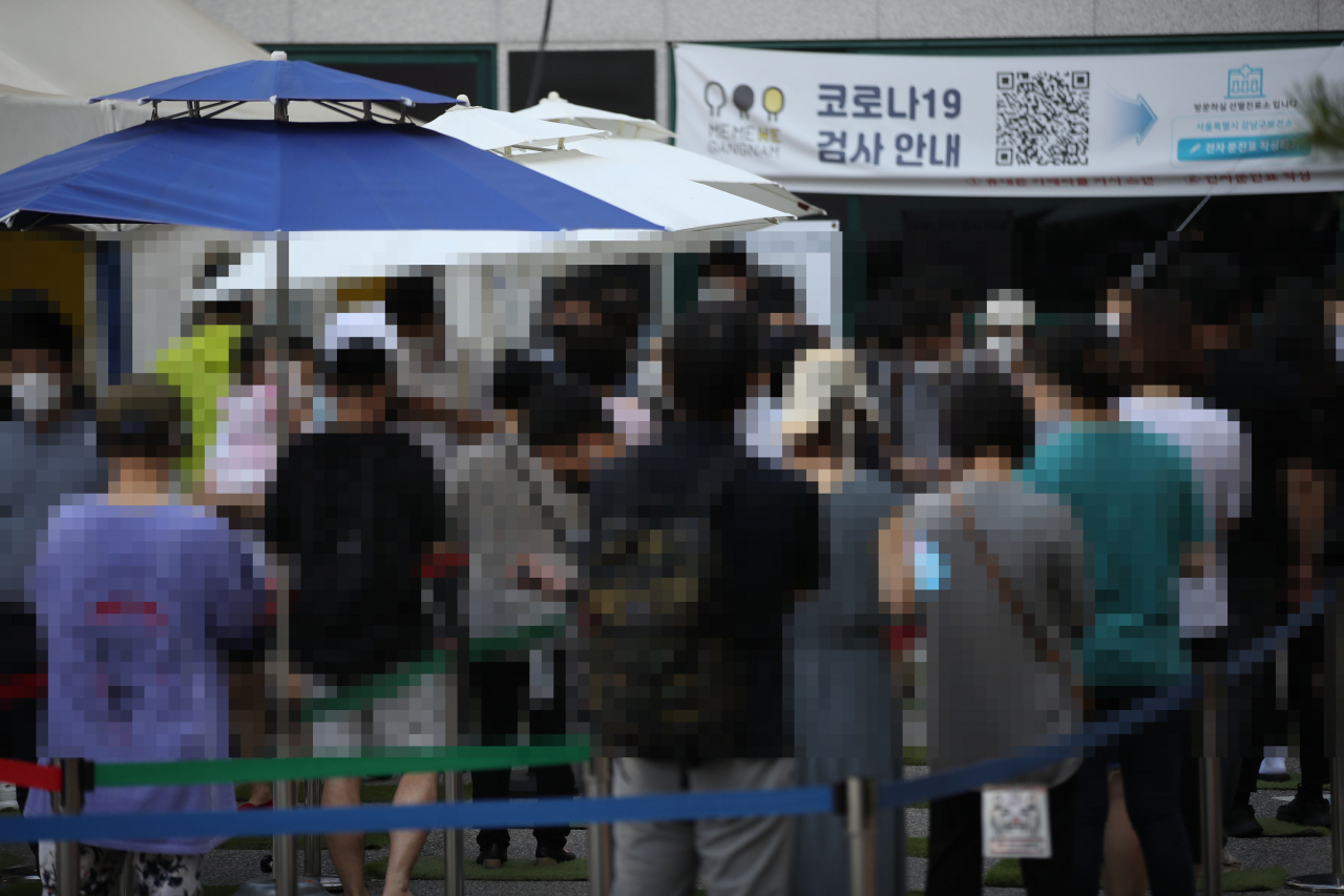 지난 20일 오전 서울 강남구보건소에 마련된 선별진료소를 찾은 시민들이 신종 코로나바이러스 감염증(코로나19) 선별검사를 받기 위해 줄을 서 있다. [연합]