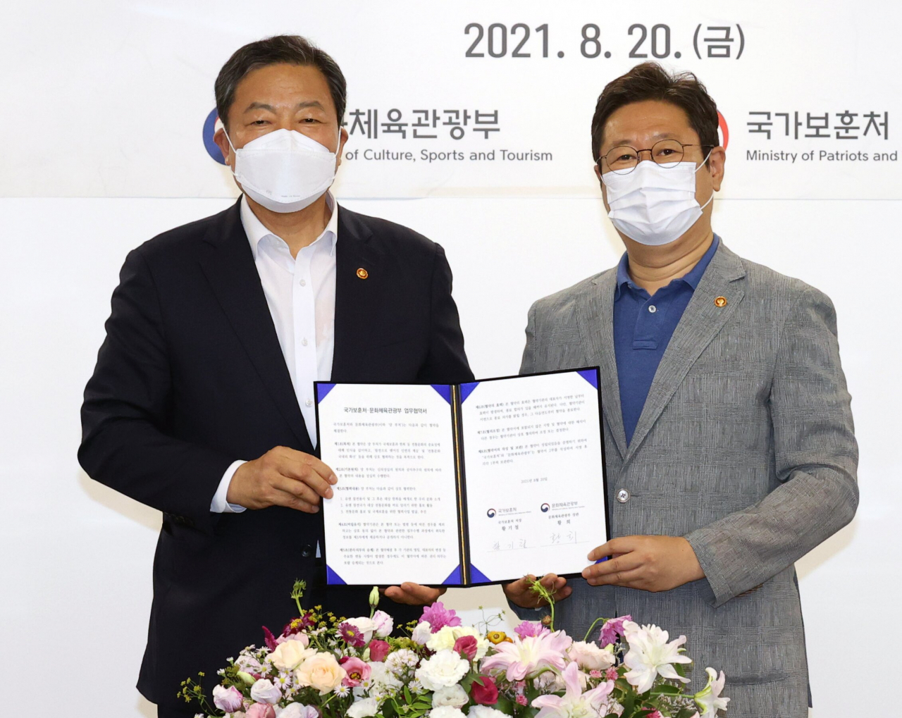 문화체육관광부 황희(오른쪽) 장관과 국가보훈처 황기철 처장이 참전용사들을 위한 문화힐링기회 확대를 골자로 하는 국제보훈 협약을 맺고 있다.