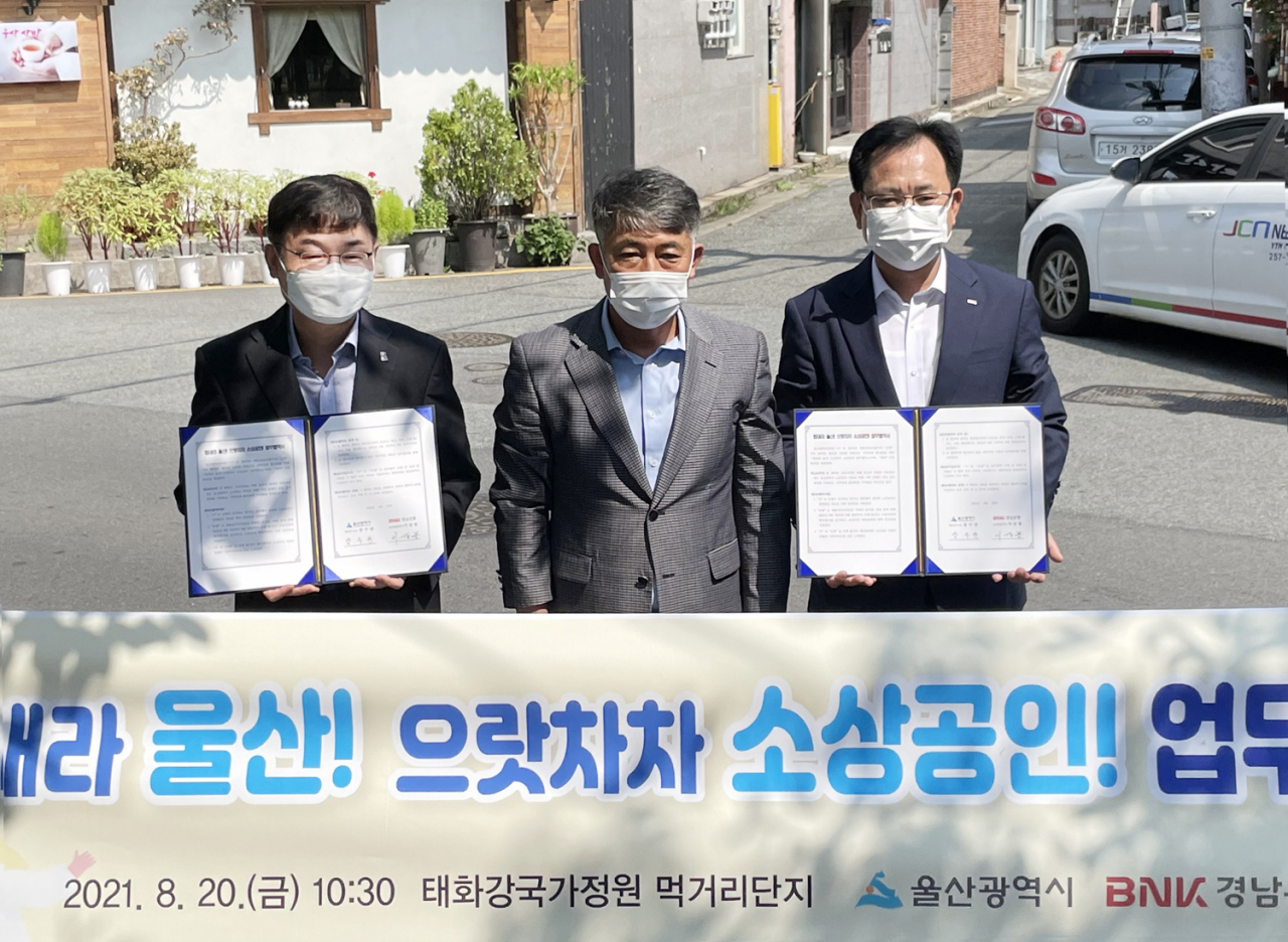 BNK경남은행 이상봉 상무(사진 오른쪽)가 울산광역시 장수완 행정부시장(사진 왼쪽)과태화강국가정원상인회 임명철 회장과 함께 ‘힘내라 울산! 으랏차차 소상공인! 업무 협약’을 체결하고 있다.