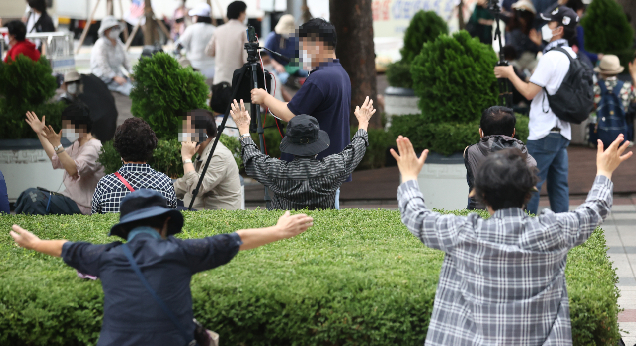 서울 성북구 사랑제일교회 신자들이 22일 서울 광화문 동화면세점 앞에서 현장 예배를 하고 있다. [연합]