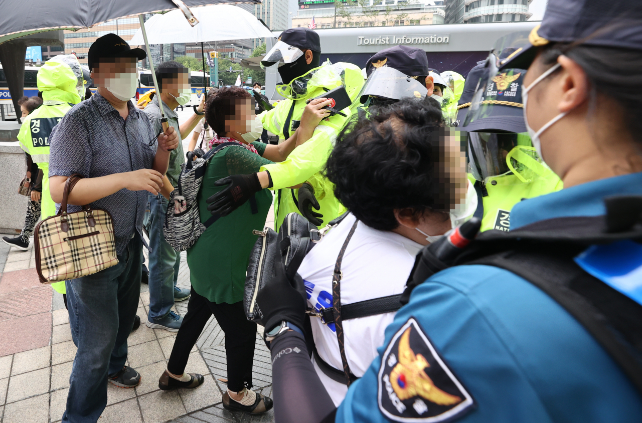 서울 성북구 사랑제일교회 신자들이 현장 예배를 위해 22일 서울 광화문 동화면세점 앞으로 모이던 중 경찰과 실랑이를 하고 있다. [연합]