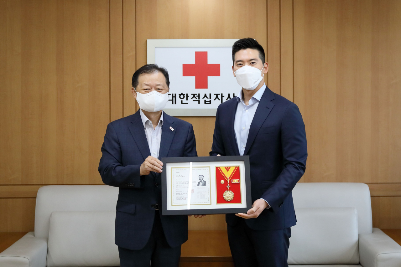 E1 구동휘 운영담당 대표이사(오른쪽)와 대한적십자사 신희영 회장(왼쪽)이 기념촬영을 하고 있다. [E1 제공]