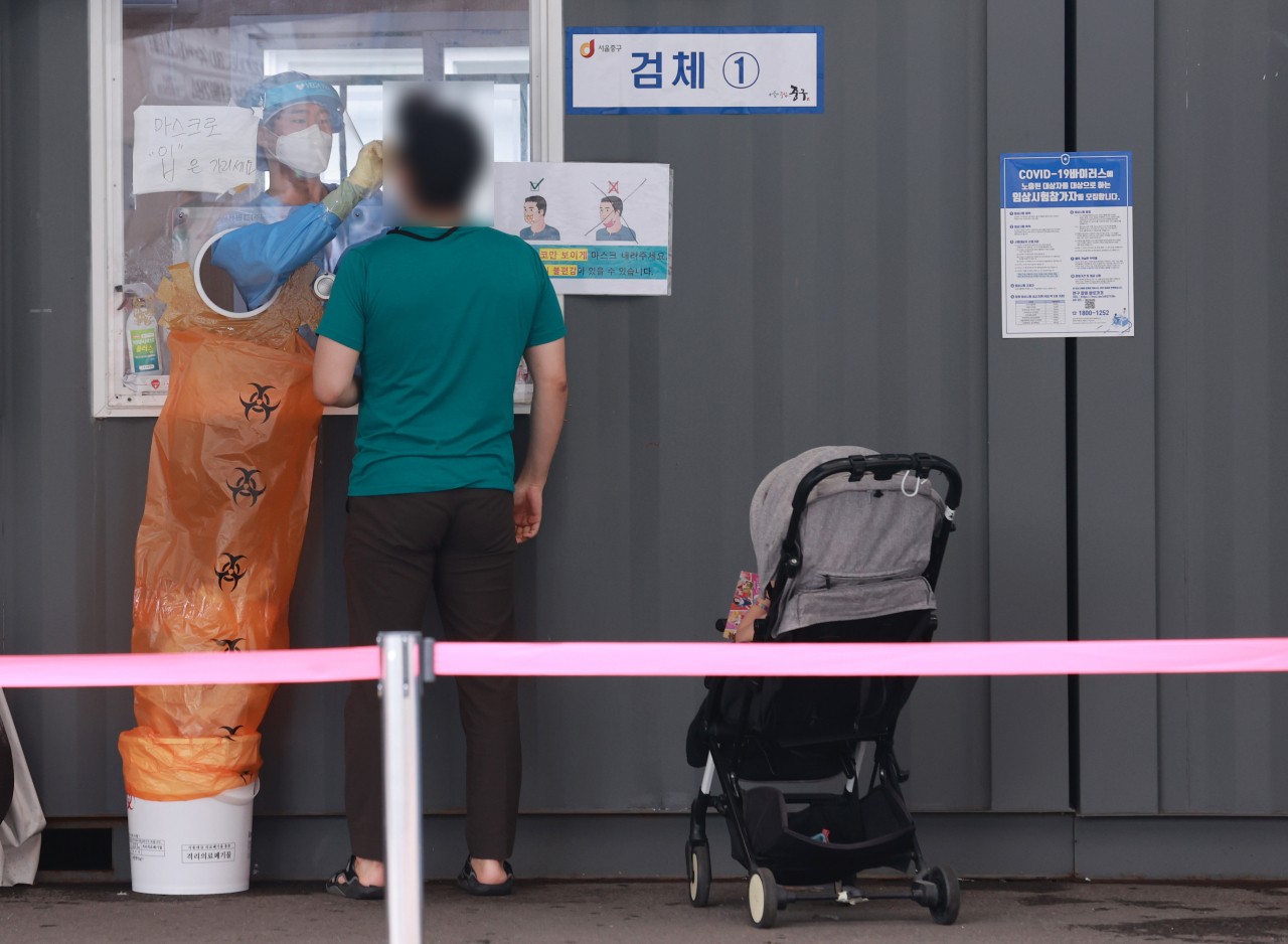 23일 오전 서울 중구 서울역 광장에 마련된 신종 코로나바이러스 감염증(코로나19) 임시 선별검사소를 찾은 시민이 검사를 받고 있다. 연합뉴스