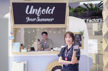 SK텔레콤 직원들이 홍대 정보통신기술(ICT)멀티플렉스 T팩토리에 설치된 폴더블 체험존을 소개하고 있다. [SK텔레콤 제공]