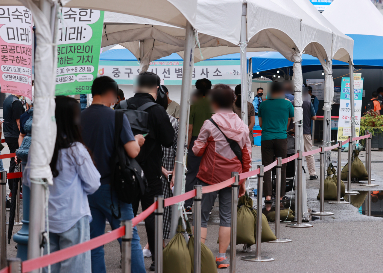 지난 23일 오전 서울 중구 서울역 광장에 마련된 코로나19 임시 선별검사소를 찾은 시민들이 검사 순서를 기다리고 있다. [연합]