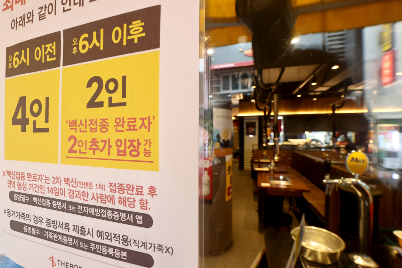 수도권 사회적 거리두기 4단계가 다음달 5일까지 2주간 연장된 지난 23일 오후 서울 종각역 인근 음식점에 관련 안내문이 붙어 있다. 이날 오후 6시부터 4단계 지역 식당·카페에 '백신접종 인센티브'가 적용돼 접종 완료자 1명 포함시 3명, 2명 포함시 4명까지 모임이 가능하다. [연합]