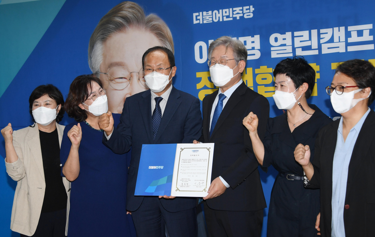 더불어민주당 대선 경선 후보인 이재명 경기도지사가 24일 서울 여의도 선거캠프에서 열린 직능단체와의 정책협약기념식에서 한국어린이집총연합회 관계자들과 포즈를 취하고 있다. 연합뉴스