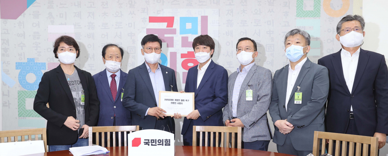 국민의힘 이준석 대표가 24일 서울 여의도 국회에서 7개 언론단체 관계자들로부터 언론중재법 개정안 철회 촉구 언론인 서명지를 전달받고 있다. 연합뉴스