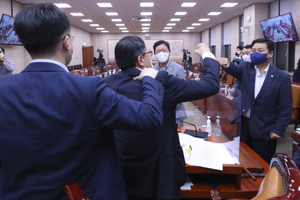 더불어민주당 김남국 의원(왼쪽 부터), 박주민 국회 법제사법위원장 직무대리, 김승원, 김영배 의원 등이 25일 서울 여의도 국회에서 열린 법제사법위원회 전체회의에서 언론중재법 개정안을 통과시킨 뒤 인사를 나누고 있다. 연합뉴스