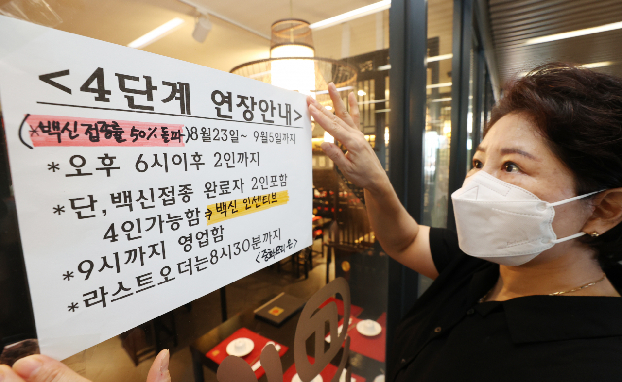 22일 서울 양천구의 한 중식당에서 해당 식당 관계자가 ‘백신 인센티브’ 안내문을 붙이고 있다. [연합]