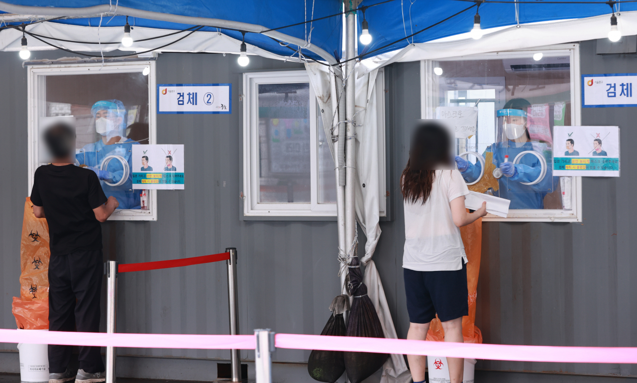 25일 오전 서울 중구 서울역광장에 마련된 신종 코로나바이러스 감염증(코로나19) 임시 선별검사소에서 의료진이 검체 채취를 하고 있다. 중앙방역대책본부는 이날 0시 기준 신규 확진자가 2155명 늘어 누적 24만1439명이라고 밝혔다. 전날(1509명)보다 무려 646명 늘면서 지난 20일(2050명) 이후 닷새 만에 다시 2000명을 넘어 2100명대를 기록했다. 이는 국내 코로나19 사태 이후 최다를 기록한 지난 11일(2221명) 이후 두 번째로 큰 규모다. [연합]