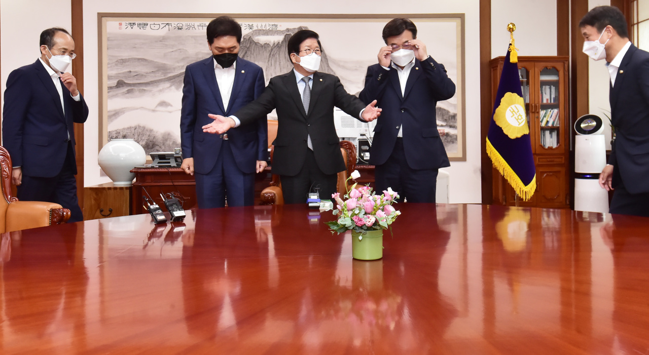 National Assembly Speaker Park Byeong-seug (center) holds a meeting with Democratic Party floor leader Rep. Yun Ho-jung (second from right) and People Power Party floor leader Rep. Kim Gi-hyeon (second from left) on Wednesday morning to discuss whether to postpone a plenary meeting scheduled for Wednesday afternoon. The parliament has postponed a plenary meeting scheduled for the day as law states that bills must not go through two legislative stages on the same day. (Yonhap)
