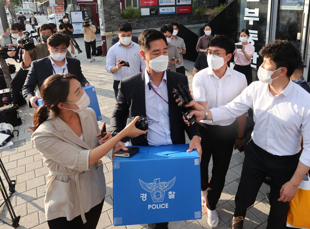 지난달 25일 오후 서울 영등포구 머지플러스 본사에서 서울경찰청 금융범죄수사대 수사관들이 압수물품을 들고 밖으로 나서고 있다. [연합]