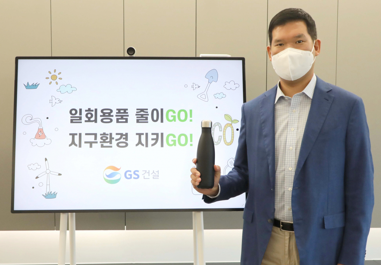 허윤홍 GS건설 신사업 부문 대표가 25일 서울 그랑서울 본사에서 생활 속 플라스틱 사용을 줄이기 위한 구호가 담긴 모니터 옆에서 탈(脫) 플라스틱 실천운동 ‘고고챌린지’에 동참하고 있다. [GS건설 제공]