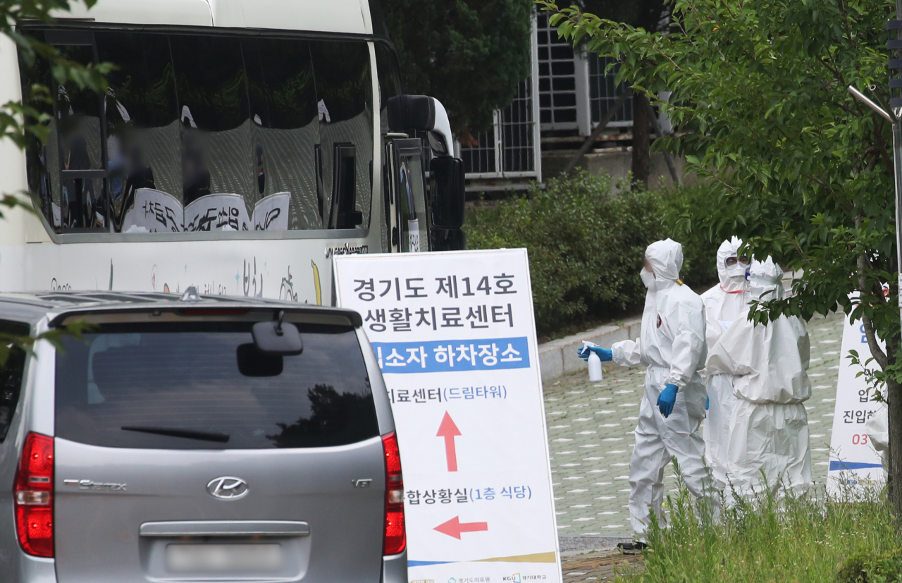 지난 11일 오후 경기도 수원시 경기대 기숙사에 설치된 경기도 제14호 생활치료센터에서 방역복을 입은 관계자들이 분주하게 움직이고 있다. [연합]