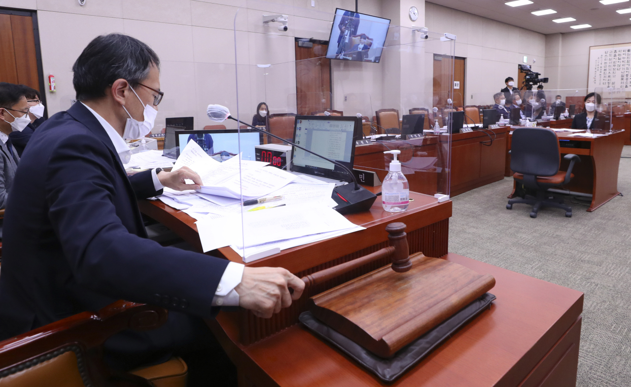 Rep. Park Ju-min of the ruling Democratic Party of Korea passes the "fake news" bill through the National Assembly's Judiciary and Legislation Committee on early Wednesday morning as he presides over the committee as interim chairman. (Yonhap)