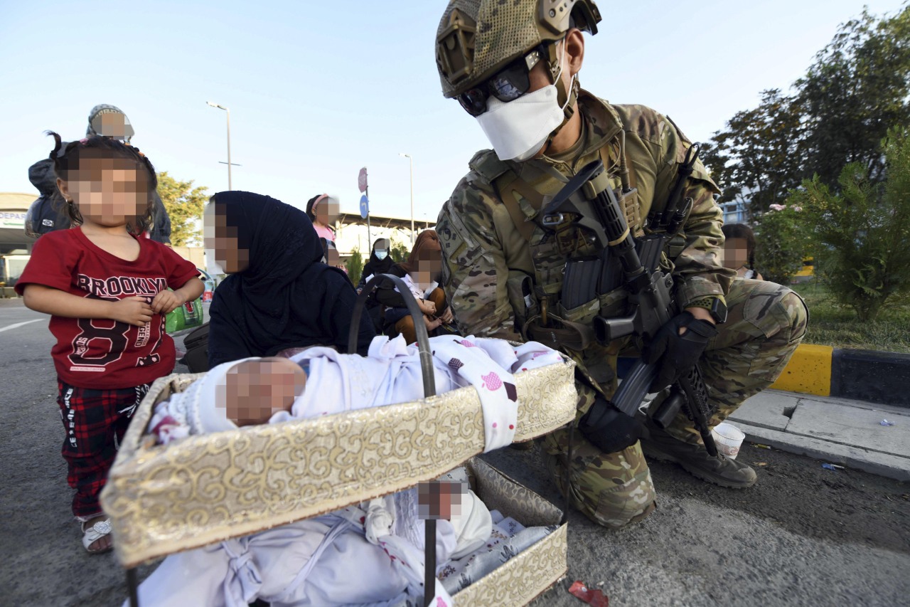 A South Korean soldier greeting an Afghan family at the Kabul airport on Thursday. (Yonhap)