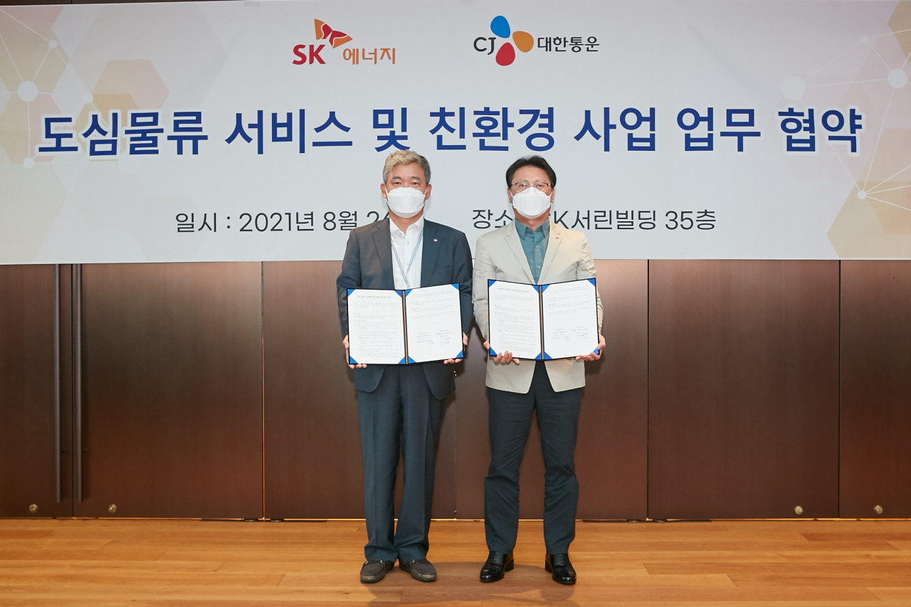 신영수 CJ대한통운 택배부문 대표(왼쪽)와 오종훈 SK에너지 P&M CIC대표가 26일 서울 종로구 SK서린빌딩에서 개최된 ‘도심 물류서비스 개발 및 친환경 차량 전환 협력’을 위한 업무협약식에서 기념촬영을 하고 있다.[SK에너지 제공]