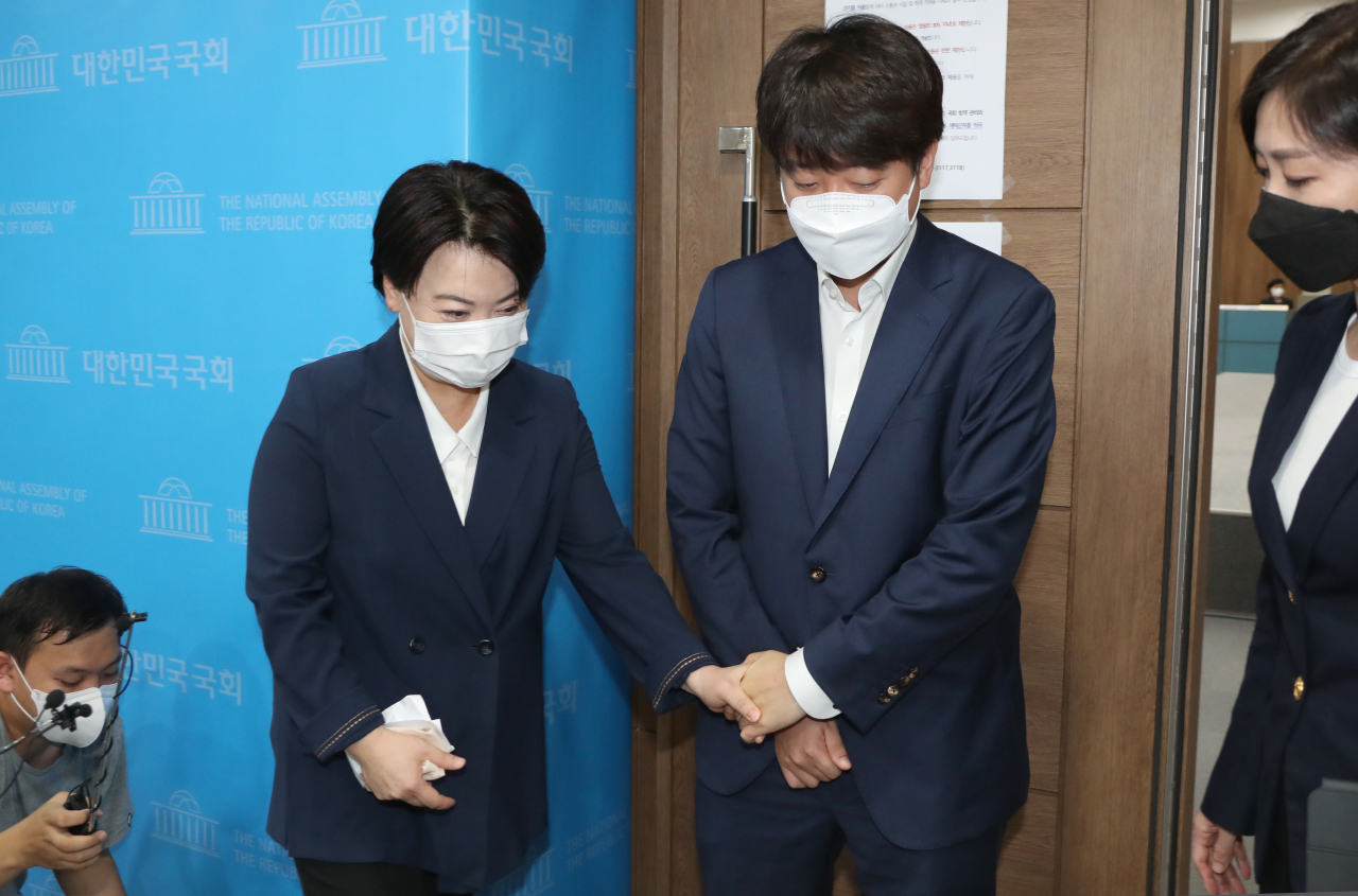 25일 국민권익위원회 조사 결과 부동산 관련 불법 의혹이 제기된 국민의힘 윤희숙 의원의 의원직 및 대선후보 사퇴 기자회견이 열린 국회 소통관을 찾은 이준석 대표가 윤 의원의 손을 잡고 소통관을 나서고 있다. 연합뉴스