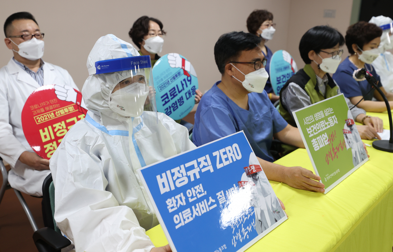지난 27일 오전 서울 영등포구 보건의료노조에서 열린 산별 총파업 찬반투표 결과 발표 기자회견에서 보건의료노조 관계자들이 손팻말을 들고 있다. 인력 확충과 처우 개선 방안을 확보하고, 감염병 전문병원 설립과 공공의료 확충 등을 촉구하는 보건의료노조는 9월 2일부터 필수인력을 남기고 총파업에 돌입한다고 밝혔다. [연합]