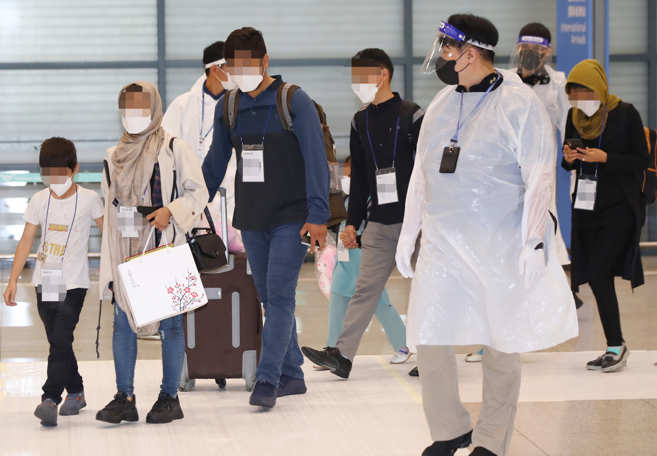아프가니스탄에서 한국 정부 활동을 도왔던 현지인 직원 및 가족 중 파키스탄에 남아 있던 나머지 인원들이 27일 오후 우리군 수송기로 인천국제공항에 도착한 뒤 입국장을 나서고 있다. [연합]