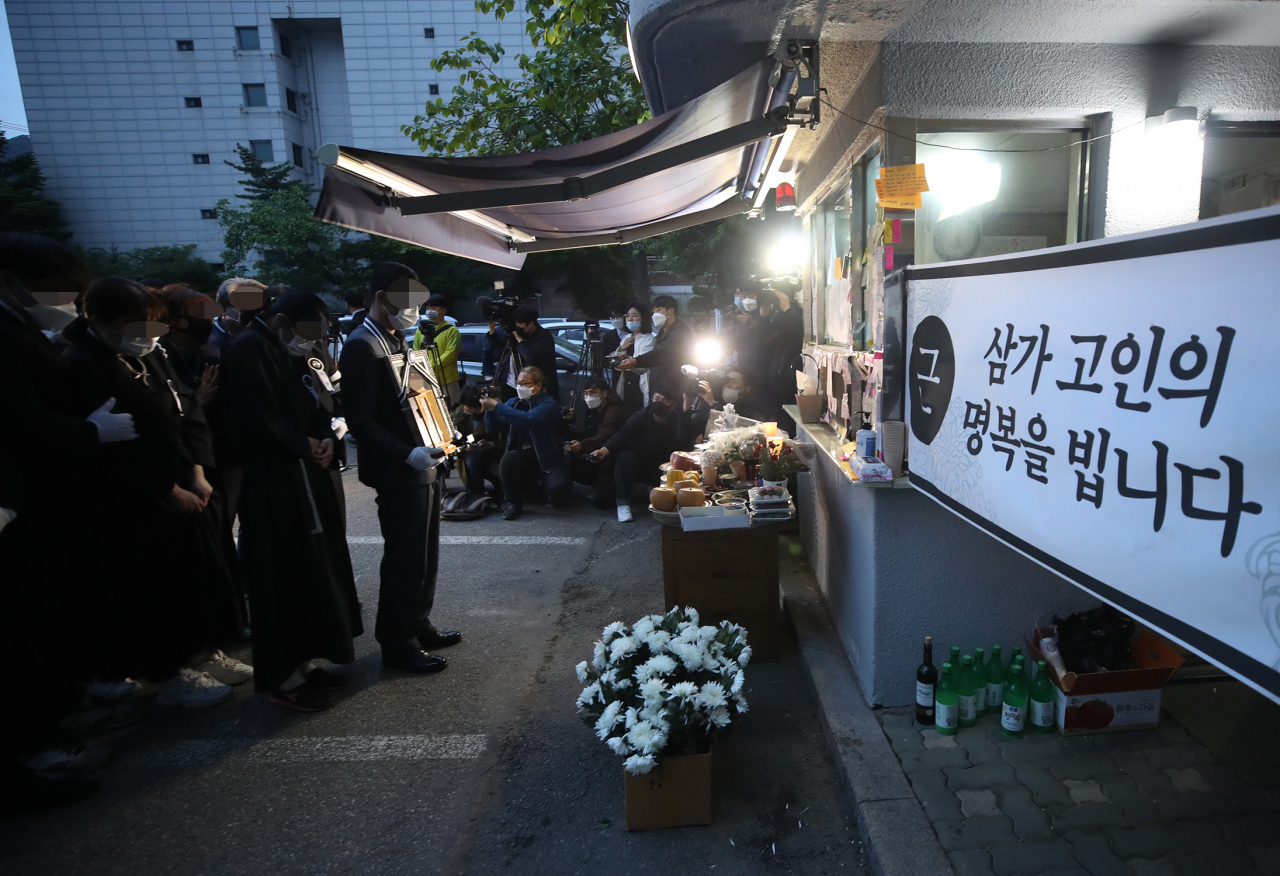 지난해 5월 14일 오전 서울 강북구 우이동의 한 아파트 경비실 앞에서 아파트 경비원으로 일하다 주민 괴롭힘에 극단적 선택을 한 최희석씨의 유족들이 노제를 지내고 있다. [연합]