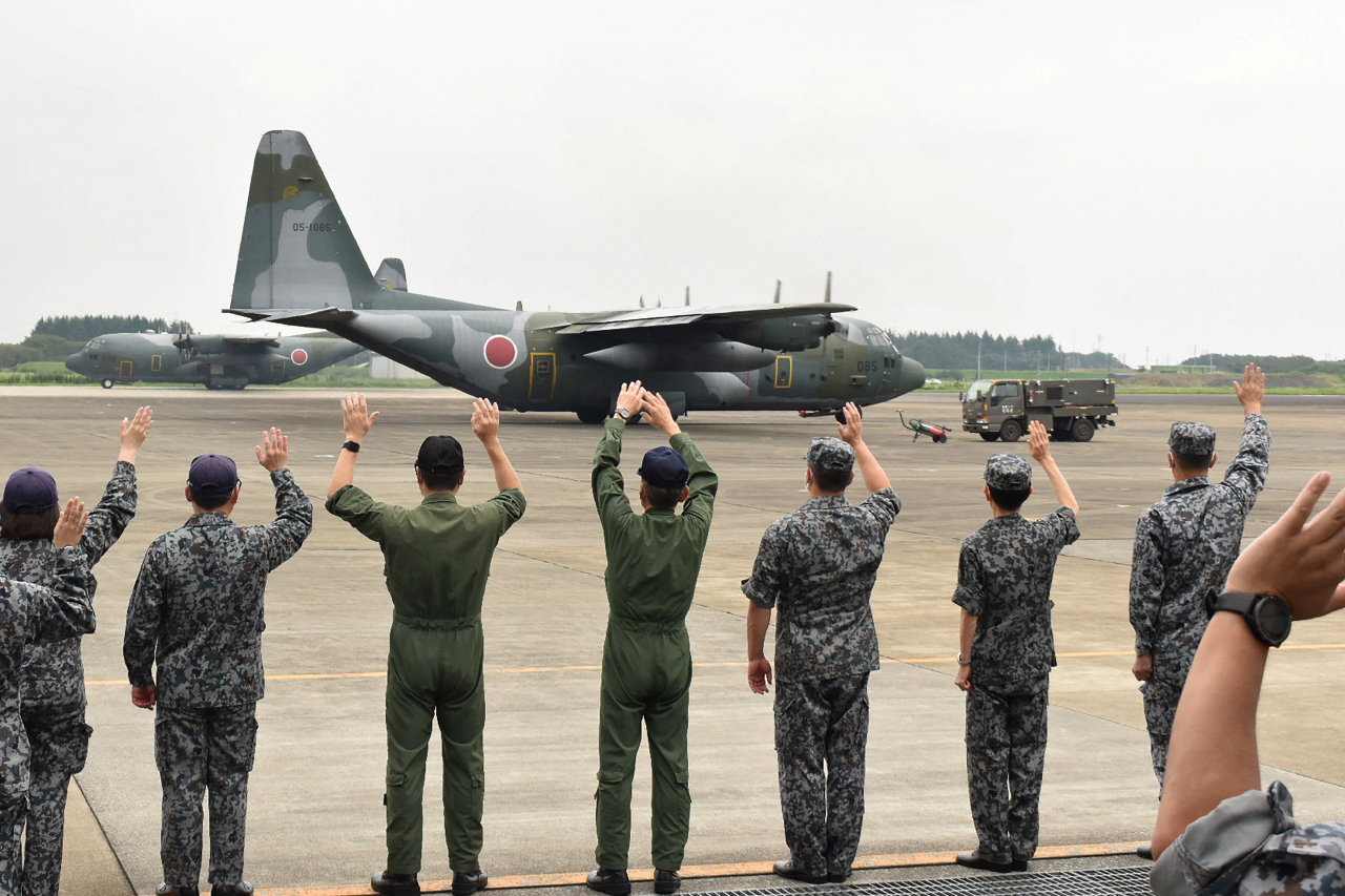 일본 항공자위대 수송기 C-130이 자국민과 현지인 조력자 대피 임무를 위해 24일 사이타마현에서 아프가니스탄으로 급파되자 이륙 전 현지 부대원들이 환송하고 있다. 하지만, 이 수송기는 아프간 현지인을 한 명도 대피시키지 못했다. [AFP]