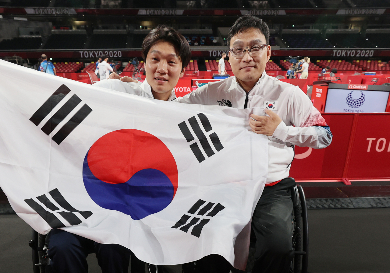 '경기 후에는 같은 대한민국 선수.' 도쿄 패럴림픽 남자 탁구 개인전(스포츠등급 1) 결승에서 금메달을 따낸 주영대(오른쪽)와 은메달을 딴 김현욱과 함께 태극기를 들고 포즈를 취하고 있다. 연합뉴스