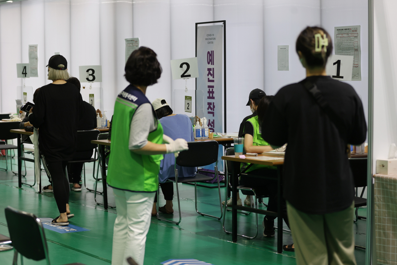 국내 코로나19 백신 1차 접종률이 56.5%를 넘어선 가운데 지난달 31일 오전 서울 서대문구 북현문화체육센터에 마련된 코로나19 예방접종센터에서 시민들이 예진표를 작성하고 있다. [연합]