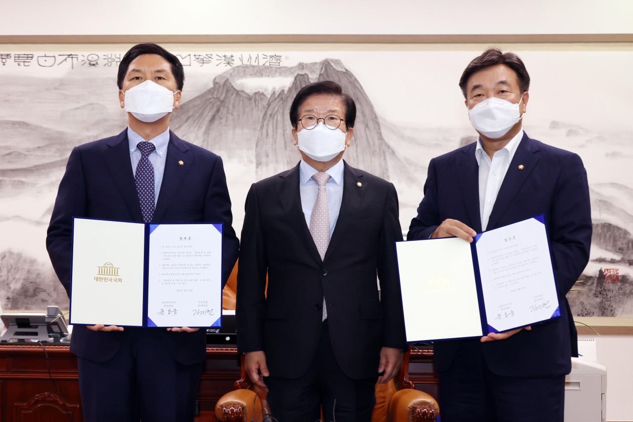 Floor leaders of the Democratic Party of Korea and the People Power Party pose for a photo with National Assembly Speaker Park Byeong-seug (center) after the two parties agree to put the "fake news" bill on hold for further negotiation. (Yonhap)