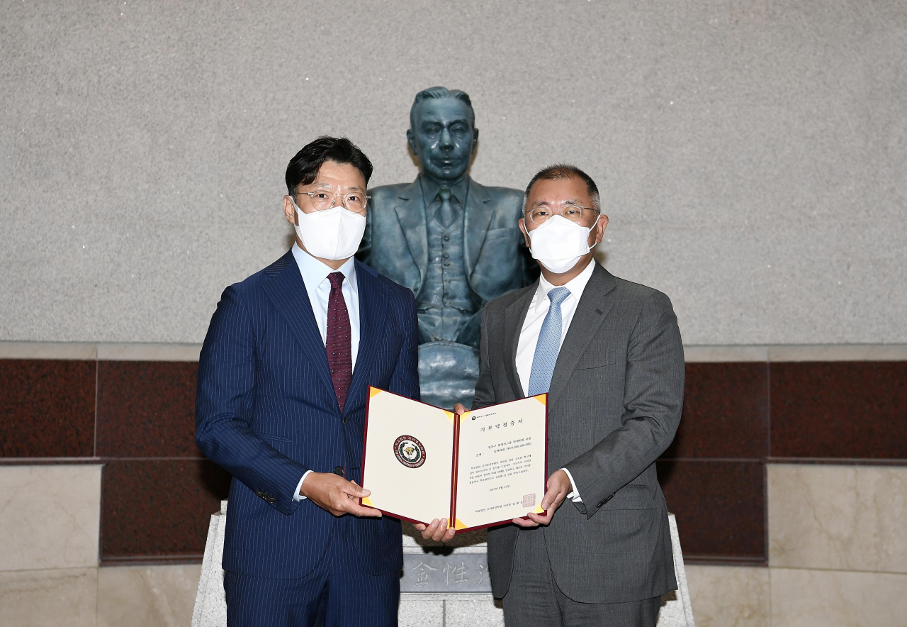 현대자동차그룹 정몽구 명예회장이 고려대학교의료원이 추진 중인 「정몽구 백신혁신센터」 설립 및 운영을 위해 학교법인 고려중앙학원에 사재 100억원을 기부한다. 현대차그룹과 고려중앙학원은 31일 고려대학교 인촌기념관에서 ‘기부금 약정 체결식’을 가졌다. 현대차그룹 정의선 회장(사진 오른쪽)이 기부금 약정서에 서명한 뒤 고려중앙학원 김재호 이사장과 기념 사진을 촬영하고 있다. [현대차그룹 제공]