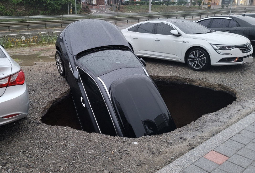 1일 오전 충남 당진시 서해로 한 공터에 대형 지반침하(싱크홀)가 발생해 차량 1대 차체 절반이상이 빠져 있다. [연합]
