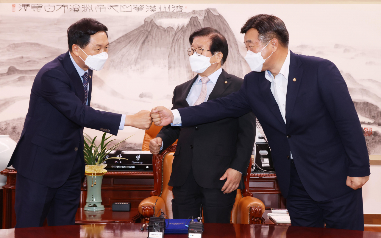 윤호중 더불어민주당 원내대표(오른쪽)와 김기현 국민의힘 원내대표가 지난달 31일 서울 여의도 국회 의장실에서 언론중재법 개정안을 위한 협의체 구성, 9월 27일 본회의 상정 등에 합의한 뒤 악수하고 있다. 가운데는 박병석 국회의장. 이상섭 기자