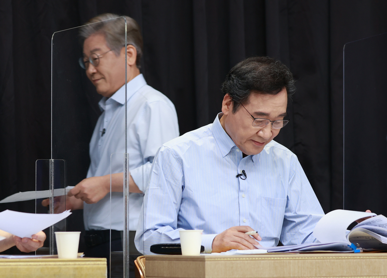 지난 1일 서울 금천구 가산디지털단지 내 스튜디오에서 열린 오마이뉴스 주관 더불어민주당 대통령선거 후보자 1대1 토론에서 이재명 경선후보가 이낙연 후보 옆을 지나고 있다. [연합]