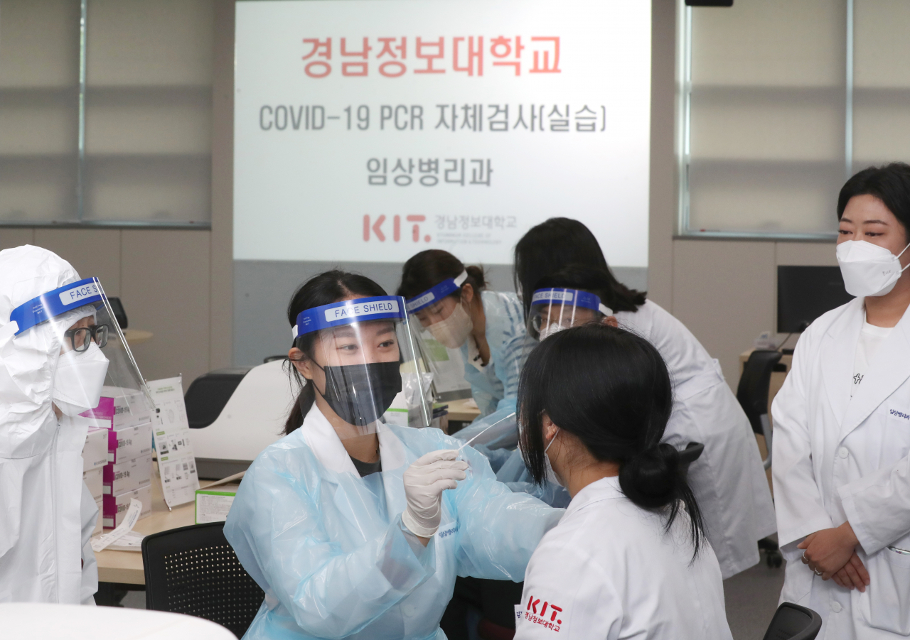 경남정보대 임상병리과 학생들이 2일 부산 사상구 대학 내에서 코로나19 진단검사 실습을 하고 있다. [연합]