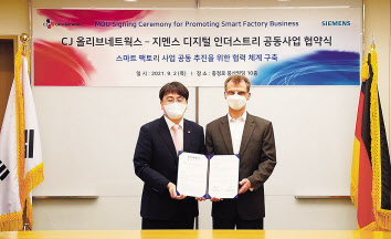 한국지멘스 본사에서 열린 업무협약식에서 차인혁(왼쪽) CJ올리브네트웍스 대표와 토마스 슈미드 한국지멘스 디지털 인더스트리 부문 대표가 기념 사진을 촬영하고 있다. [CJ올리브네트웍스 제공]