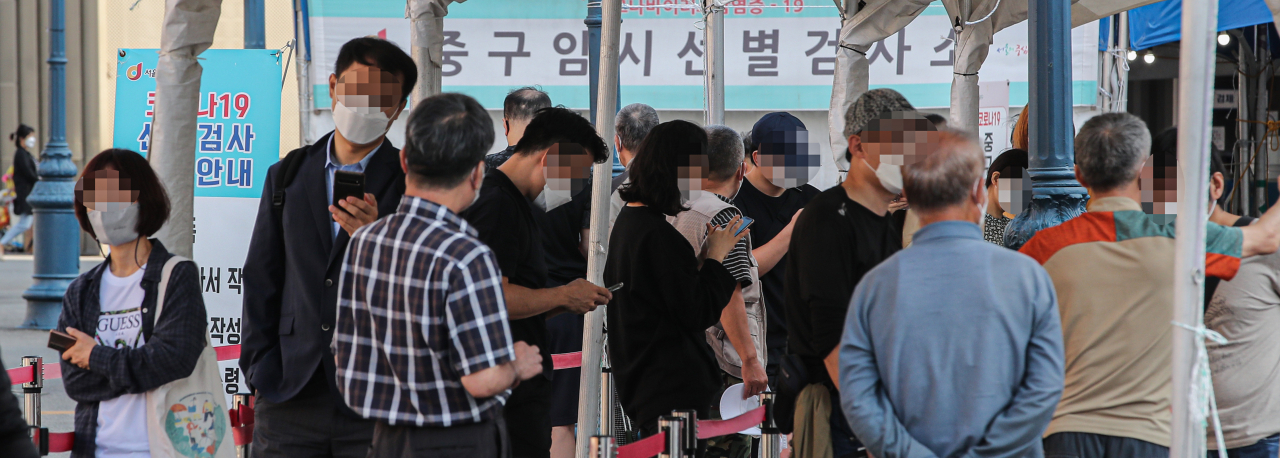 3일 오전 서울 중구 서울역 광장에 설치된 코로나19 선별검사소에 검사를 받으려는 시민들이 줄지어 서 있다. 이날 보건당국이 발표한 코로나19 신규 확진은 1709명을 기록, 59일째 네 자릿수를 기록했다. [연합]