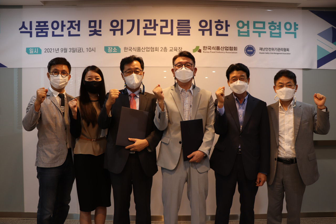 유무영 재난안전위기관리협회 이사(왼쪽에서 세번째)과 김명철 한국식품산업협회 부회장(네번째)이 화이팅을 외치며 기념촬영을 하고 있다. [한국식품산업협회 제공]