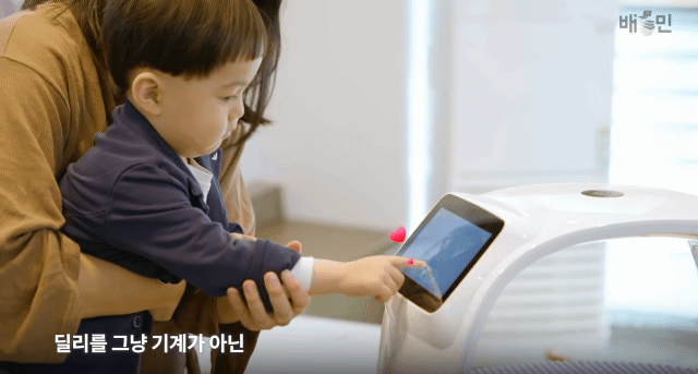 딜리 플레이트가 실제 배치된 매장에서 아이가 딜리 플레이트를 만지는 모습. [배달의민족 제공]