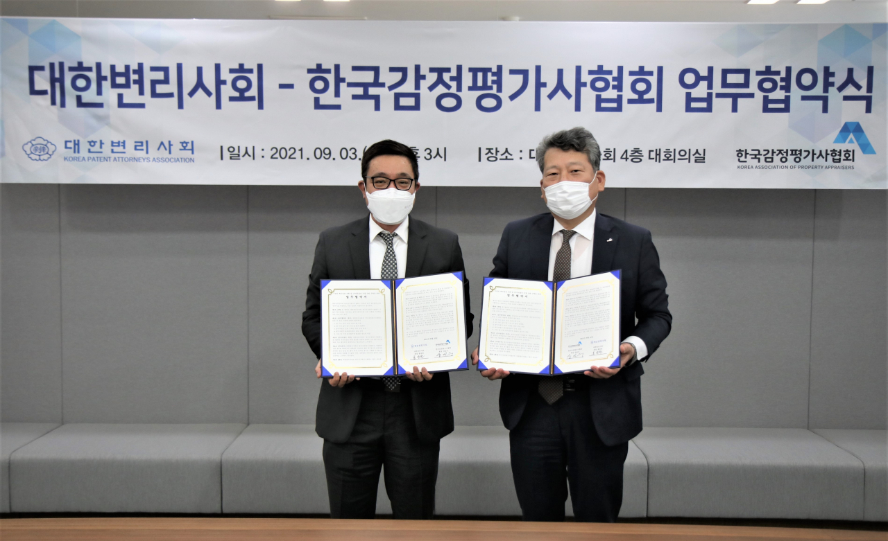 한국감정평가사협회 양길수 회장(오른쪽)과 대한변리사회 홍장원 회장이 업무협약 체결 후 기념촬영을 하고 있다. [한국감정평가사협회 제공]