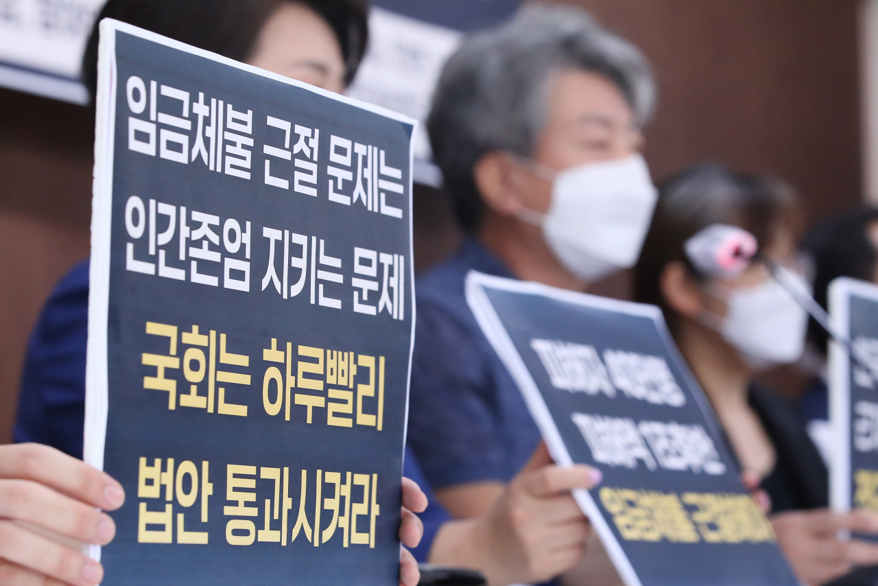 6일 오전 서울 종로구 참여연대에서 열린 임금체불 근절을 위한 근로기준법 개정안 발의 기자회견에서 참석자들이 손팻말을 들고 있다. [연합]