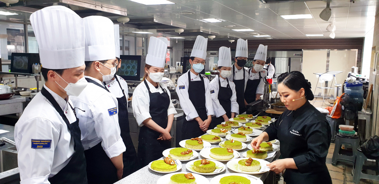 와이즈유 영산대학교 조리예술학부 K-Food조리전공 이수진(사진 오른쪽) 교수가 학생들을 대상으로 한식 교육기관 지원사업의 일환인 한국전통 병과실습교육을 실시하고 있다. [영산대 제공]